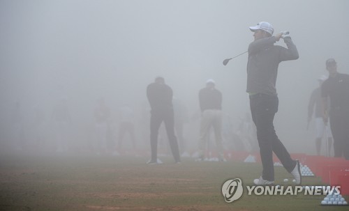 안개 때문에 경기가 지연되자 선수들이 연습 레인지에서 몸을 풀고 있다.