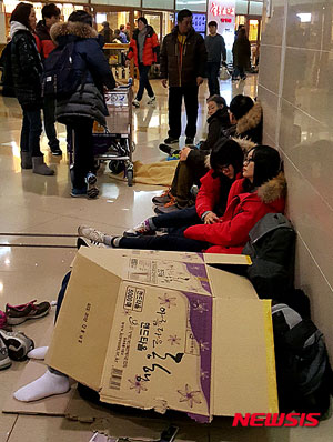 24일 아침 제주공항 내 한 항공사의 발권데스크 앞에서 많은 체류객들이 비행기 재운항을 기다리고 있다. 이날 제주공항은 제설작업으로 인해 정오까지 활주로를 폐쇄한다고 밝혔다.