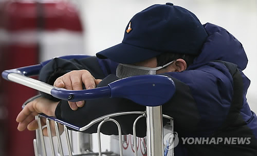 사상 초유의 제주공항 항공기 중단 사태가 3일째 이어진 25일 새벽 고단 하루를 마친 체류객들이 제주공항 여객터미널에서 잠을 자고 있다. (제주=연합뉴스)