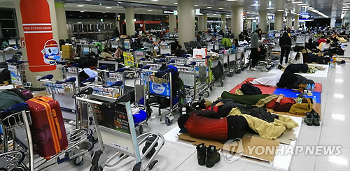 사상 초유의 제주공항 항공기 중단 사태가 3일째 이어진 25일 새벽 고단 하루를 마친 체류객들이 제주공항 여객터미널에서 잠을 자고 있다. (제주=연합뉴스)
