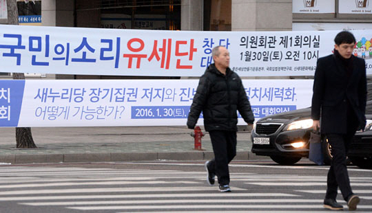 28일 국회 앞 거리에 4·13 총선을 겨냥한 정당 행사 일정을 알리는 현수막들이 즐비한 가운데 시민들이 출근길을 서두르고 있다. 김선규 기자 ufokim@
