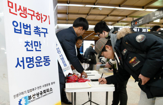 부산상공회의소가 4일 부산지하철 1호선 서면역에 마련한 ‘민생 구하기 입법촉구 1000만 서명운동’ 부스에서 시민들이 서명을 하고 있다.  대한상공회의소 제공