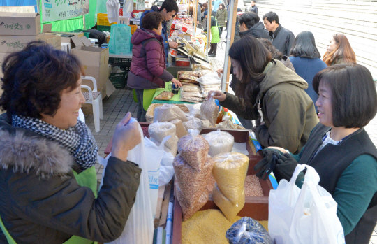 지난 1월 28일 서울 서초구 서울고법 동관 1층 로비 앞에서 열린 ‘서울고법과 함께하는 설 직거래 큰 장터’를 찾은 인근 지역 주민들이 매대에 놓인 농산물을 구매하고 있다.  김낙중 기자 sanjoong@
