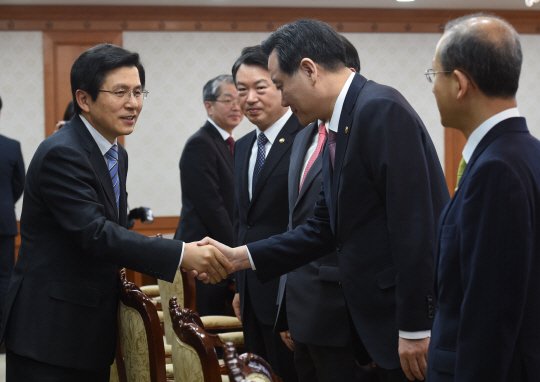 4일 오전 정부서울청사에서 열린 공명선거관계장관회의에 앞서 황교안(왼쪽) 국무총리가 김현웅 법무부 장관과 악수를 하고 있다.