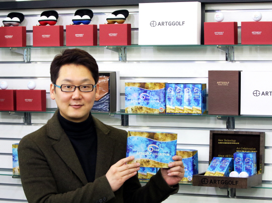 송희준 대표가 전시된 탄 골프볼을 들어 보이고 있다.