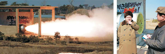 김정은(오른쪽 사진 왼쪽) 북한 국방위원회 제1위원장이 고출력 고체 로켓 발동기(엔진) 지상 분출 및 계단분리시험(단 분리 시험)을 지도했다고 노동당 기관지 노동신문이 24일 보도했다. 고체 연료가 화염을 내뿜는 실험장(왼쪽 사진) 벽면에는 ‘미제와 박근혜패당에게 무자비한 불벼락을!’이란 문구가 적혀 있다.  연합뉴스