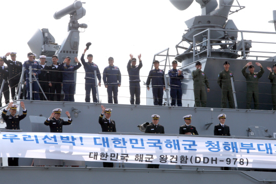 청해부대 21진(왕건함·4400t급) 소속 장병들이 23일 해군 작전사령부 부산기지에서 가족들의 환송을 받으며 아덴만으로 출항하고 있다.  연합뉴스