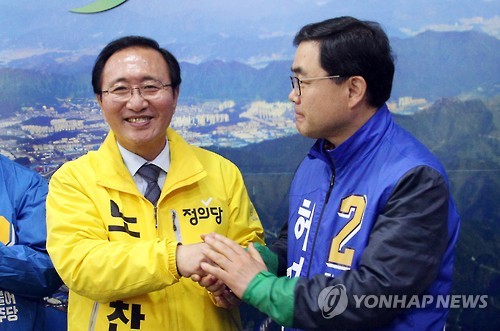 (창원=연합뉴스) 전화 여론조사를 통해 경남 창원성산 야권 단일후보로 선정된 노회찬 정의당 후보가 29일 경쟁자였던 허성무 더불어민주당 후보와 악수하고 있다.