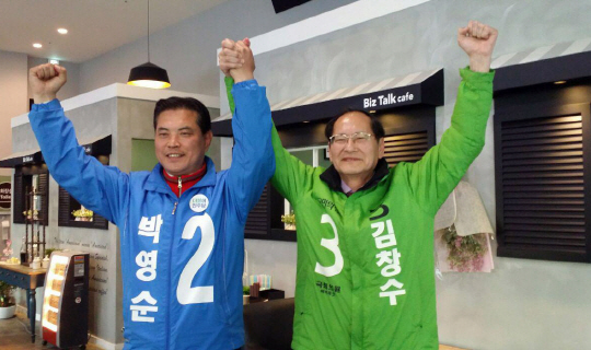대전 대덕에 출마한 박영순(왼쪽) 더불어민주당 후보와 김창수 국민의당 후보가 29일 후보 단일화에 합의한 뒤 손을 맞잡고 두 팔을 들어 보이고 있다. 연합뉴스