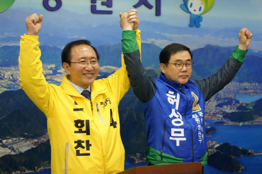 경남 창원성산의 노회찬(왼쪽) 정의당 후보와 허성무 더불어민주당 후보가 29일 노 후보로의 야권 단일화 협상 결과를 발표한 뒤 손을 잡아 들어 보이고 있다.  뉴시스