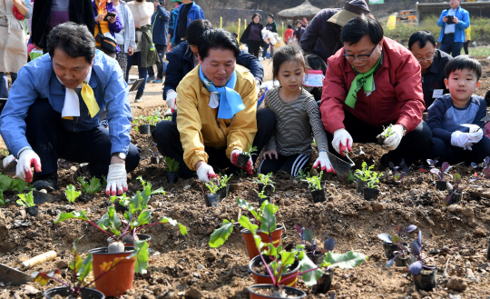 2일 서울 강동구 명일근린공원 공동체텃밭에서 열린 ‘2016 도시농업의 날’ 행사에서 이동필(오른쪽 두 번째) 농림축산식품부 장관과 김병원(오른쪽 네 번째) 농협중앙회장, 이양호(오른쪽 다섯 번째) 농촌진흥청장이 어린이들과 함께 텃밭에서 모종을 심고 있다.