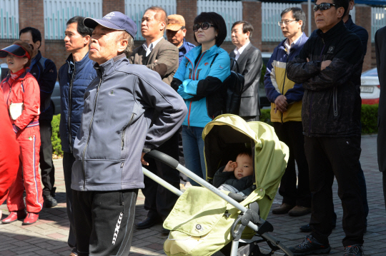 5일 오전 대전 한민시장에서 유모차에 손자를 태운 할아버지가 다른 시민들과 함께 새누리당 후보의 선거 유세를 듣고 있다.