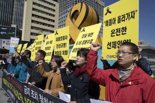 전교조 회원들이 4일 서울 광화문광장에서 교육부의 ‘세월호 계기수업 교재 활용금지’ 조치 철회를 촉구하는 구호를 외치고 있다. 연합뉴스