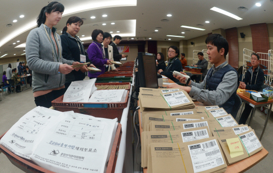 6일 오전 인천 중구 국제우편물류센터에서 선거관리위원회 직원들이 해외에서 받은 제20대 국회의원 총선거 재외투표 우편물을 해당 지역구 선관위에 보내기 위해 센터 직원에게 제출하고 있다.