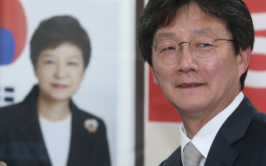 대구 동을에 무소속으로 출마해 당선된 유승민 의원이 13일 자신의 선거사무소에서 미소를 짓고 있다. 유 의원 뒤로 사무실에 걸려 있는 박근혜 대통령의 사진이 보인다.