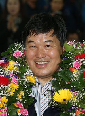 대구 북을에서 당선된 홍의락 무소속 후보가 13일 꽃다발을 목에 걸고 두 팔을 들어 당선 인사를 하고 있다.  연합뉴스