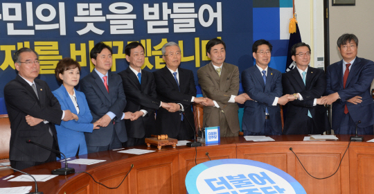 18일 오전 국회에서 열린 더불어민주당 비상대책회의에서 김종인(가운데) 대표와 비대위원들이 엇갈려 손을 잡은 채 총선 민의를 열심히 받들겠다고 다짐하고 있다.