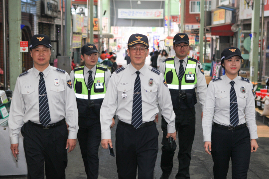 정명시(가운데) 울산 중부경찰서장과 직원들이 21일 울산 중구 병영동 선우시장에서 도보순찰 거리만큼 어려운 이웃에 기부하는 ‘희망순찰’을 벌이고 있다.  울산지방경찰청 제공
