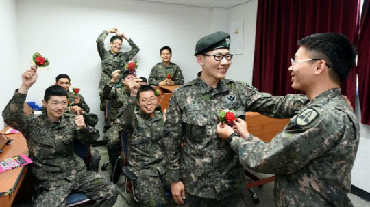 육군 52사단 천마학교 교실 선생님 김형우(오른쪽 두 번째) 대위가 안준형 병장으로부터 카네이션을 받고 있다.  국방일보 제공