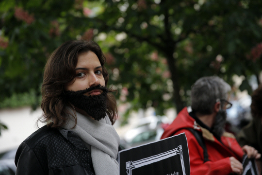 지난 11일 프랑스 파리 국회의사당 앞에서 가짜 수염을 단 여성이 프랑스 정치권의 성차별 철폐 시위에 참여하고 있다. 프랑스에서는 최근 정부 및 정치권 고위인사들의 잇단 성희롱 발언과 행동이 드러나면서 15일 전·현직 여성 장관들이 성폭력에 항의하는 비난 성명을 발표하는 등 파문이 확산되고 있다.