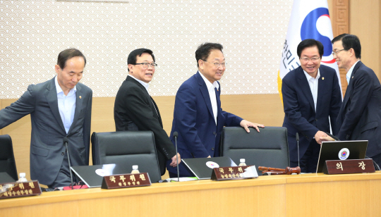 유일호(가운데) 부총리 겸 기획재정부 장관과 윤성규(왼쪽) 환경부·이동필(〃 두 번째) 농림축산식품부 장관 등 국무위원들이 24일 오전 정부세종청사에서 열린 영상국무회의에 앞서 인사를 나누고 있다.  연합뉴스