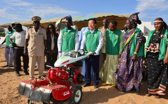 경상북도가 새마을세계화사업의 일환으로 조성 중인 세네갈 탈바흘레 새마을 시범마을에서 김관용(가운데) 경북지사가 농기계 운전을 시연하고 있다.