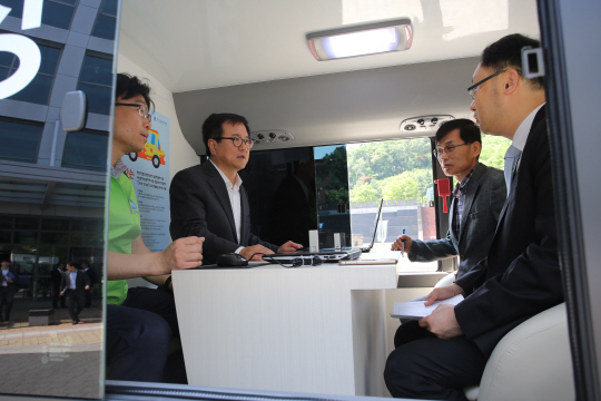 1일 김병기(왼쪽 두 번째) 경기신용보증재단 이사장이 미니버스를 개조한 이동상담소에서 상공인들을 만나 보증상담을 하고 있다.    경기신용보증재단 제공