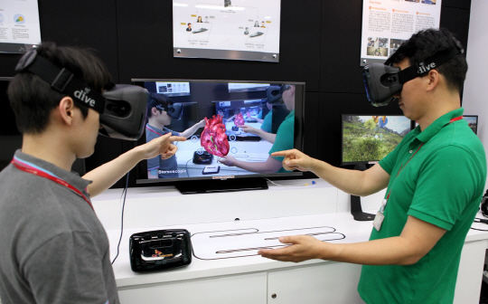 지난 5월 26일 경기 성남시 분당구 SK텔레콤 종합기술원 가상현실체험관에서 연구원들이 구글의 ‘탱고’가 탑재된 착용형(웨어러블) 증강·가상현실(AVR) 감상 기기(HMD·Head Mount Display)를 통해 ‘원격 AVR’를 테스트하고 있다.