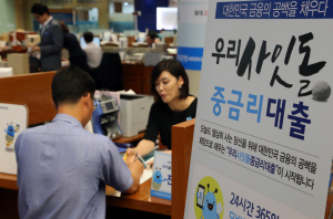 연 6~10% 안팎의 중금리 신용대출 상품인 ‘사잇돌 대출’이 지난 5일 전국 9개 은행 지점에서 일제히 출시된 가운데 이날 서울 회현동 우리은행 본점에서 한 고객이 창구에서 대출 상담을 받고 있다.  연합뉴스