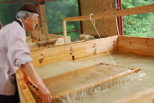 한지 전문가가 발을 이용해 초지(종이 뜨기)를 하고 있다.