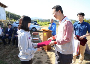 지난해 강원 홍천군 산초울마을을 찾은 김수천 아시아나항공 사장이 장학금을 전달하고 있다.