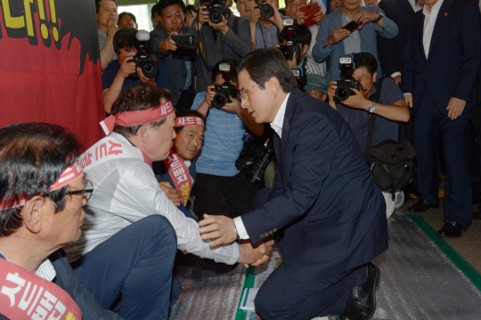 15일 오전 경북 성주군청을 방문한 황교안(오른쪽) 국무총리가 무릎을 꿇은 채 김항곤 성주군수의 손을 잡고 인사를 하고 있다. 김호웅 기자 diverkim@