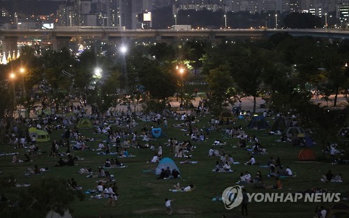 찜통더위가 계속된 10일 저녁 서울 한강시민공원 여의도지구를 찾은 시민들이 텐트와 돗자리 등을 펼친 채 더위를 식히고 있다