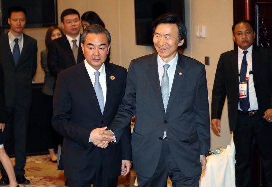 윤병세(오른쪽) 외교부 장관이 25일 오전 라오스 비엔티안 돈찬팰리스 호텔에서 열린 한·중 외교장관 회담에서 왕이 중국 외교부장과 악수하고 있다. 윤 장관은 웃으면서 손을 꽉 잡은 반면에 왕 부장은 굳은 표정으로 손을 완전히 잡지 않고 있다.