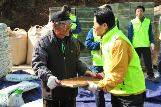 김병원 농협중앙회장이 지난 4월 경기 안성시 고삼면에서 열린 ‘범농협 전국 동시 영농지원 발대식’ 후 모판을 나르고 있다.  농협중앙회 제공
