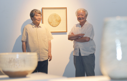 오수환(왼쪽)·윤광조 작가가 7월 27일 서울 종로구 인사동 가나아트센터에서 고 장욱진 화백의 1984년 작품을 사이에 놓고 추억담을 나누고 있다. 작품은 장 화백의 흙도판 위 못그림을 윤 작가가 화장토로 마무리한 것이다. 김낙중 기자 sanjoong@