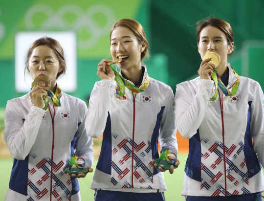 2016 리우데자네이루올림픽 여자 양궁 단체전 금메달을 딴 장혜진(왼쪽부터), 최미선, 기보배가 8일 오전(한국시간) 브라질 리우 삼보드로무 경기장에서 열린 시상식에서 금메달에 입을 맞추거나 금메달을 깨물면서 기뻐하고 있다.  연합뉴스