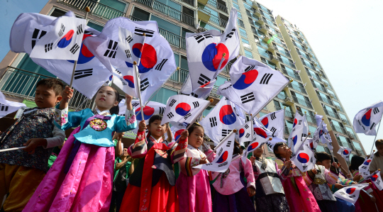 8일 오전 서울 성동구가 광복절(15일)을 앞두고 ‘태극기 달기 시범 아파트’로 선정한 홍익동 청계대주파크빌 아파트에서 한복을 입은 유치원 원아들이 태극기 달기를 호소하며 기를 흔들고 있다.