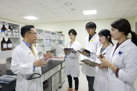 이용철(왼쪽) 전북대 의학전문대학원 교수가 9일 의과대 실험실에서 연구원들에게 중증 천식 치료제 개발 연구에 대해 설명하고 있다.