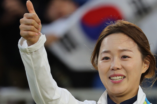 장혜진이 12일 오전(한국시간) 브라질 리우데자네이루 삼보드로무 경기장에서 열린 리우올림픽 여자 양궁 개인전에서 금메달을 목에 건 뒤 엄지손가락을 펴 보이며 눈물을 글썽이고 있다.  연합뉴스