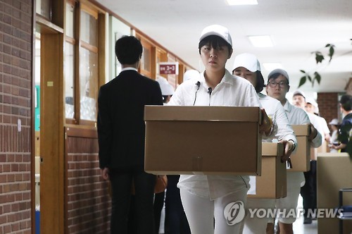 (안산=연합뉴스) 세월호 참사 당시 2학년 학생과 교사들이 사용하던 ‘기억교실’ 임시 이전이 시작된 20일 오전 경기도 안산시 단원고등학교에서 유가족과 자원봉사자들이 유품이 든 상자를 들고 나오고 있다. 안산교육지원청 별관으로 이전되는 기억교실의 책상과 추모 메모를 비롯한 기억 물품은 4·16 안전교육시설이 건립될 때까지 한시적으로 보존·전시된다.