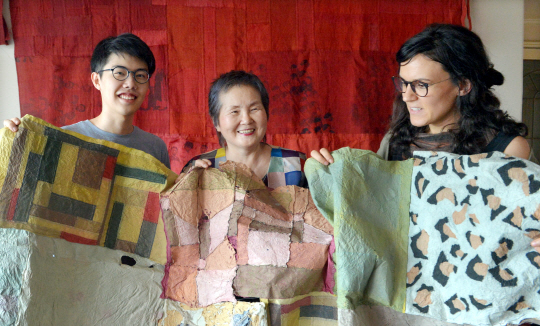 이정희(가운데) 미국 로드아일랜드디자인대 교수가 제자들과 함께 조각보를 들어 보이며 보자기 작품의 아름다움에 대해 설명하고 있다.   김낙중 기자 sanjoong@