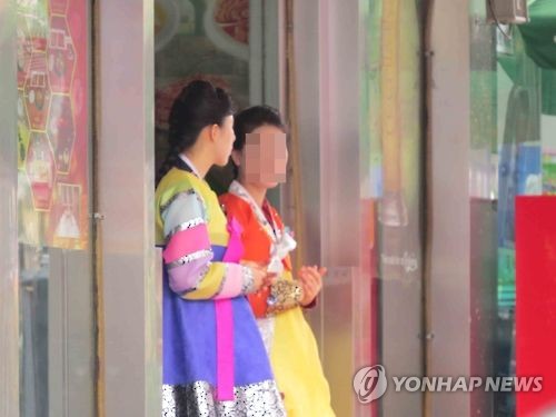 중국 랴오닝(遼寧)성 선양(瀋陽)시 시타(西塔)의 한 북한 식당 입구에서 여종업원 2명이 손님을 기다리며 서 있다. [연합뉴스 자료사진]