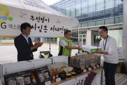경기 성남시 분당구 LIG넥스원 판교하우스에서 지난 9월 6일 열린 ‘추석맞이 일사일촌 사내장터’에서 일일도우미로 나선 이정식(가운데) LIG넥스원 사장과 강원 인제군 인제읍 하추마을의 김재노 이장이 잡곡을 판매하고 있다. LIG넥스원 제공