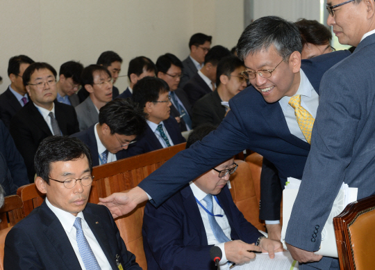 12일 오전 열린 국회 기획재정위원회의 기획재정부 국정감사에서 최상목 기재부 1차관이 ‘미르·K스포츠 재단 의혹’과 관련해 출석한 이승철 전국경제인연합회 상근 부회장의 어깨를 두드리고 있다.