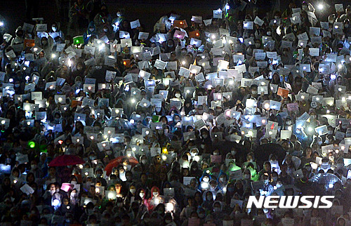 【서울=뉴시스】7일 오후 서울 서대문구 이화여자대학교에서 열린 최경희 총장 사퇴 촉구 3차 총시위에서 재학생과 졸업생들이 손피켓과 핸드폰을 들고 ‘최경희 총장 사퇴’를 요구하고 있다.