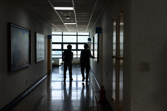 12일 경기 안성시 삼죽면 하나원 교육관 복도를 걸어가는 탈북민 두 명의 그림자가 길게 드리워지고 있다. 탈북민들은 한국 입국 이후 통일부 산하 하나원에서 3개월 동안 사회 적응 교육을 받는다.