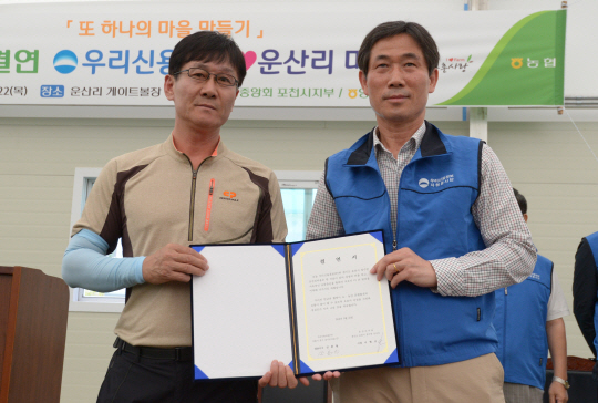 이현규(왼쪽) 운산리 마을 이장과 김종원 우리신용정보 대표의 1사1촌 결연 모습.