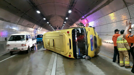 지난 9월 2일 부산 기장군 곰내터널에서 유치원 버스가 빗길에 미끄러져 넘어지자 경찰과 119구급대가 원아들의 구조작업을 하고 있다 .