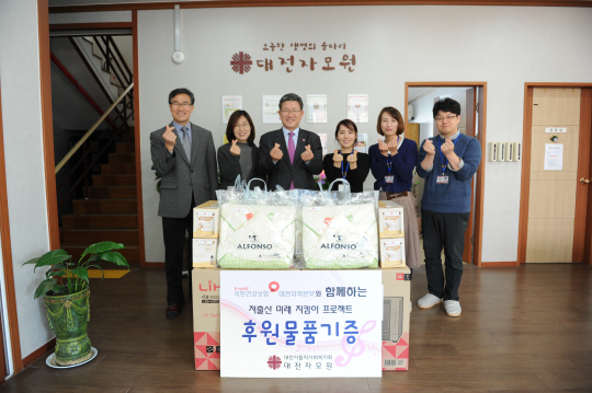 건강보험공단 임직원들이 지난해 말 한부모 가정 보호시설인 대전 대덕구 상서동 대전자모원에서 생필품을 지원한 뒤 기념사진을 찍고 있다.